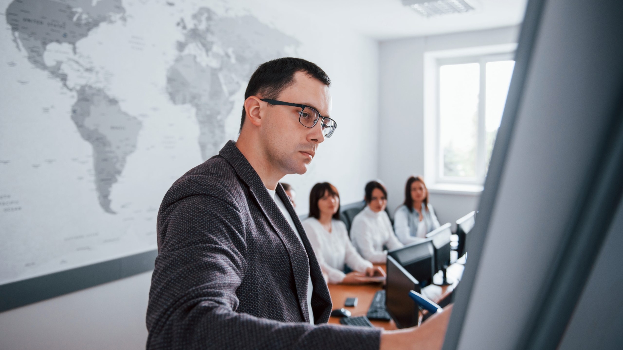 Showing example on the whiteboard. Group of people at business conference in modern classroom at daytime.